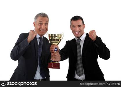 Businessmen holding a golden cup
