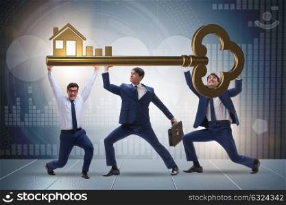 Businessmen holding giant key in real estate concept