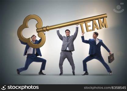 Businessmen holding giant key in team concept