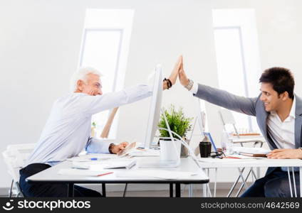 Businessmen in office cheering at their success. Celebrating their victory