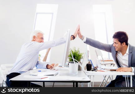 Businessmen in office cheering at their success. Celebrating their victory