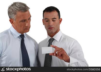 businessmen looking at a business card