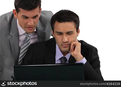 Businessmen looking at a laptop