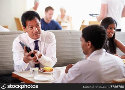 Businessmen Meeting Over Breakfast In Hotel Restaurant