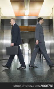 Businessmen moving towards elevators