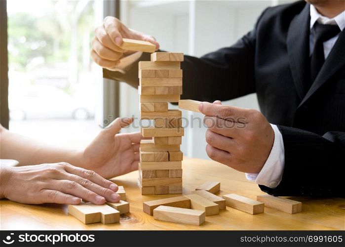 Businessmen picking domino blocks to fill the missing dominos and protect domino to fail. Growing business concept.