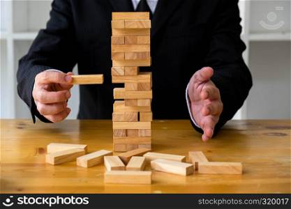 Businessmen picking dominoe blocks to fill the missing dominos and protect domino to fail. Growing business concept.