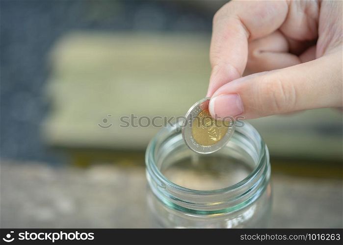 Businessmen Put the coin in a glass jar To save money, save money on investments, spend money when needed And use in the future. Investment concept. Savings with copy spaces.
