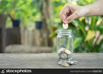 Businessmen Put the coin in a glass jar To save money, save money on investments, spend money when needed And use in the future. Investment concept. Savings with copy spaces.