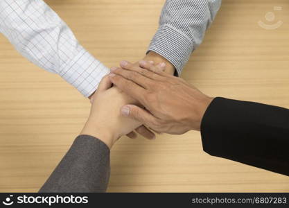 businessmen put their hand together for use as unity, cooperation and teamwork concept