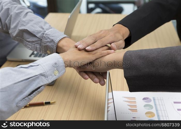 businessmen put their hand together for use as unity, cooperation and teamwork concept