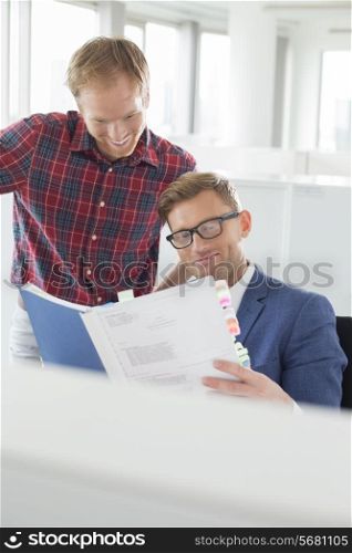 Businessmen reading file in creative office