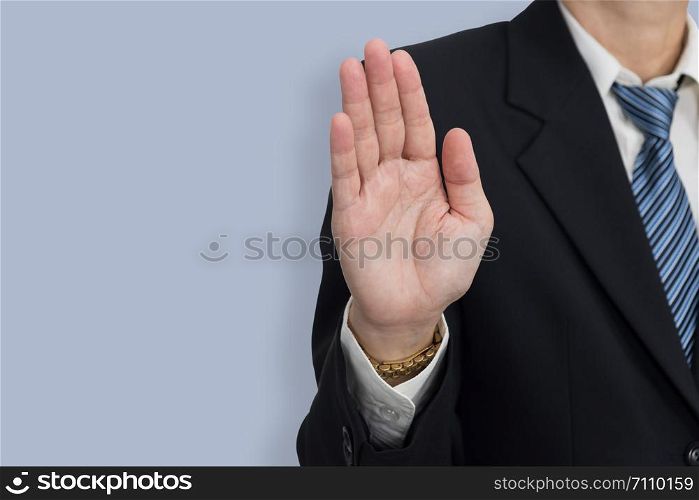 Businessmen show hand as a stop sign on blue background with copy space.