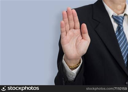 Businessmen show hand as a stop sign on blue background with copy space.