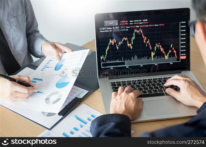 Businessmen talking about stock market invest trading online analysis discussing financial graph for investment purposes discussion in traders office