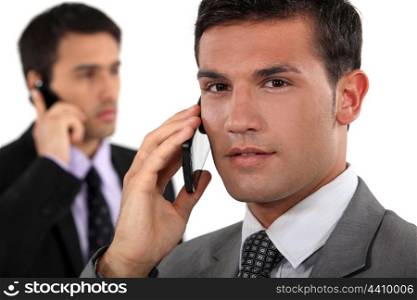 Businessmen talking on their mobile phones