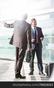 Businessmen talking while waiting for taxi in the airport