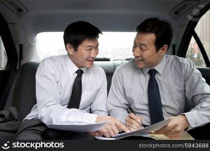 Businessmen toasting in back of car