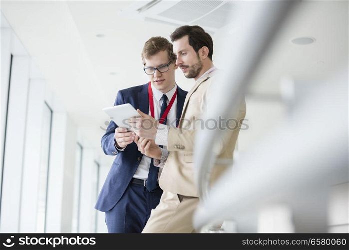 Businessmen using digital tablet in convention center