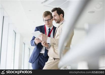 Businessmen using digital tablet in convention center