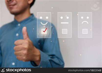Businessmen wearing a light blue shirt to selecting the level of satisfaction score icons with copy space. Customer service experience and business satisfaction survey concept