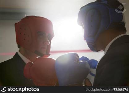 Businessmen with boxing gloves facing each other
