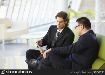 Businessmen With Digital Tablet Sitting In Modern Office