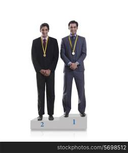 Businessmen with medals standing on a podium