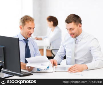 businessmen with notebook and tablet pc discussing graphs on meeting