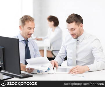 businessmen with notebook and tablet pc discussing graphs on meeting