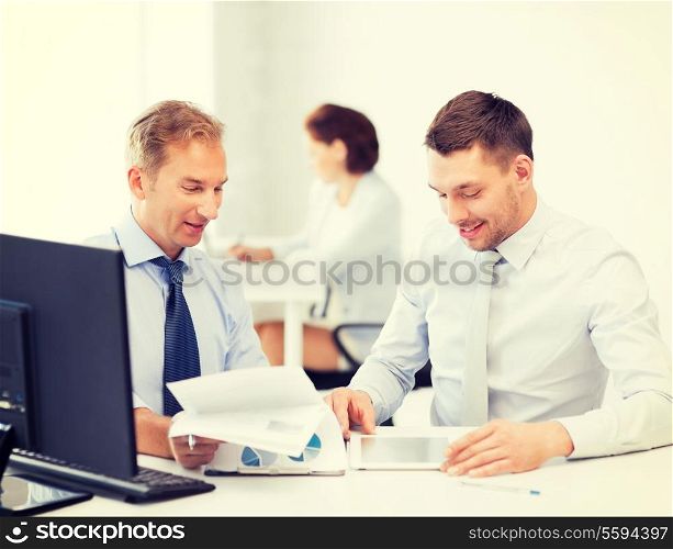 businessmen with notebook and tablet pc discussing graphs on meeting
