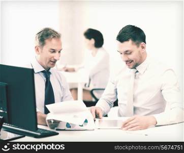 businessmen with notebook and tablet pc discussing graphs on meeting