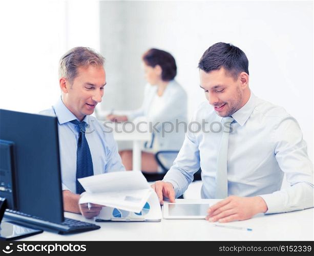businessmen with notebook and tablet pc discussing graphs on meeting. businessmen with notebook and tablet pc