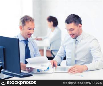 businessmen with notebook and tablet pc discussing graphs on meeting. businessmen with notebook and tablet pc