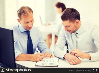 businessmen with notebook discussing graphs on meeting