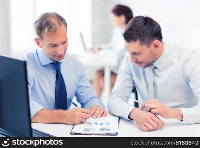 businessmen with notebook discussing graphs on meeting. businessmen with notebook on meeting