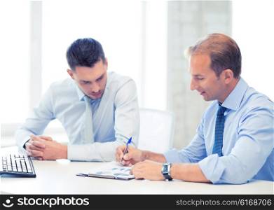 businessmen with notebook discussing graphs on meeting. businessmen with notebook on meeting