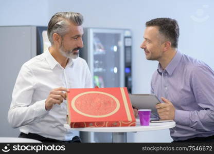 businessmen with pizza and digital tablet in rest area