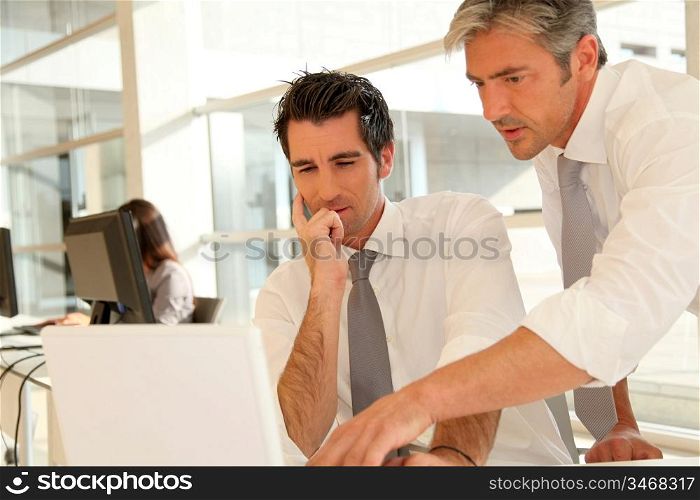 Businessmen working together on laptop computer
