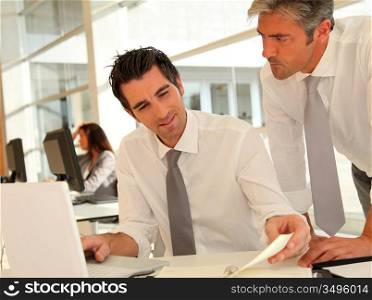 Businessmen working together on laptop computer
