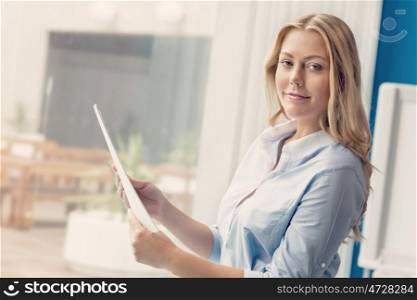 Businessowman standing next to window with papers