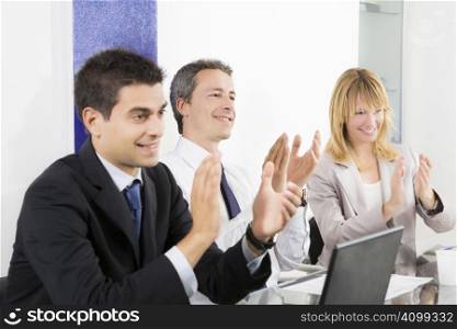 Businesspeople clapping in business meeting.