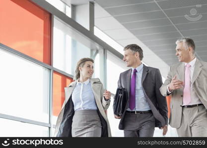 Businesspeople communicating while walking on railroad platform