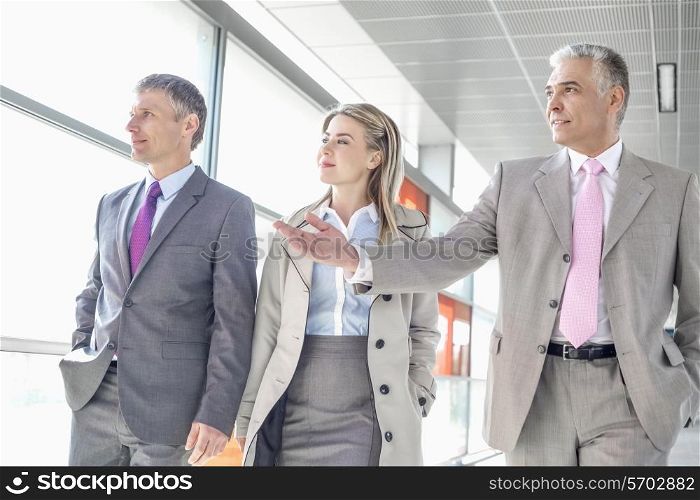 Businesspeople communicating while walking on train platform