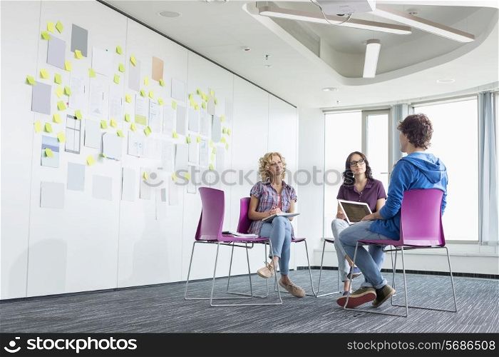 Businesspeople discussing in creative office space