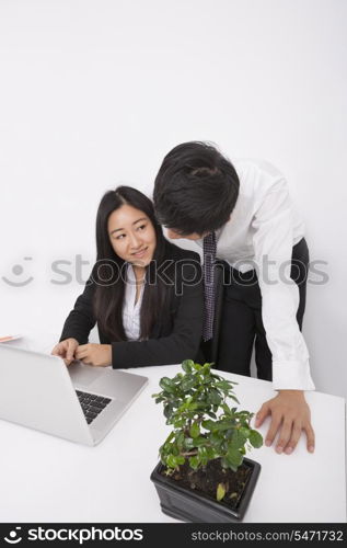 Businesspeople discussing over laptop at office desk