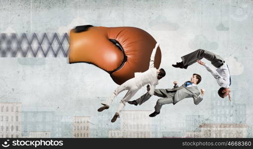 Businesspeople fighting with boxing glove. Boxing glove on spring striking group of businesspeople