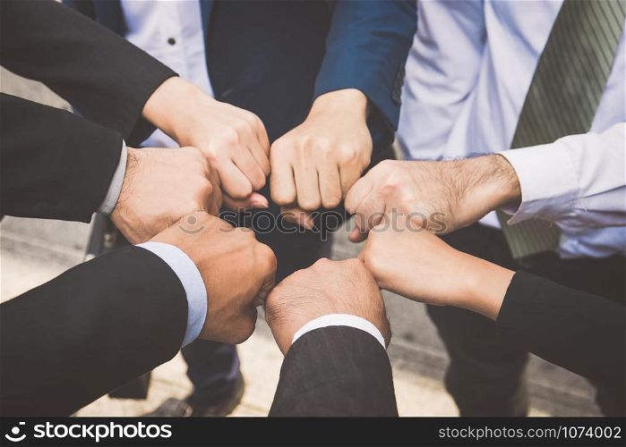 Businesspeople hands in fists in circle, business and teamwork concept