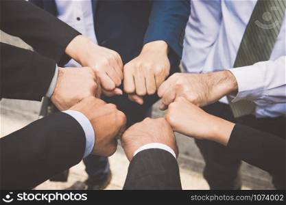 Businesspeople hands in fists in circle, business and teamwork concept