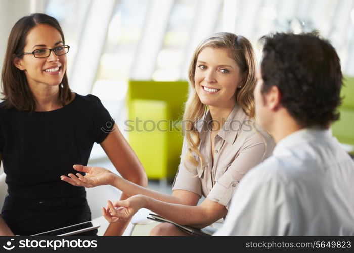 Businesspeople Having Meeting Around Table In Modern Office